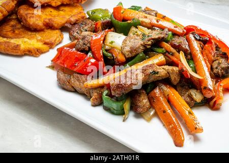 Gehackte Steak- oder Bistec Picao- und Patacone- oder Tostones sind gebratene grüne Plantaschscheiben, die aus grünen Kochbananen, Tipischen Panamá-Lebensmitteln, Panamá, Centr. Hergestellt werden Stockfoto