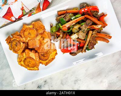 Gehackte Steak- oder Bistec Picao- und Patacone- oder Tostones sind gebratene grüne Plantaschscheiben, die aus grünen Kochbananen, Tipischen Panamá-Lebensmitteln, Panamá, Centr. Hergestellt werden Stockfoto