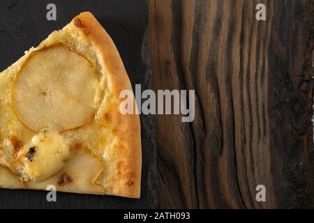 Schneiden Sie in Scheiben köstliche frische Pizza Tortilla mit Birnen und Käse Dor Blue auf dunklem Hintergrund. Draufsicht, Kopierbereich. Stockfoto