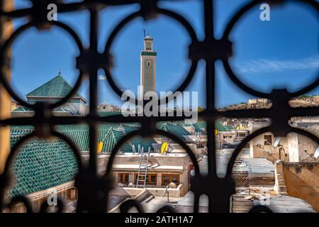 Blick über die alte Medina durch das metallene Fenster mit runden Formen in Fes, Marokko Stockfoto