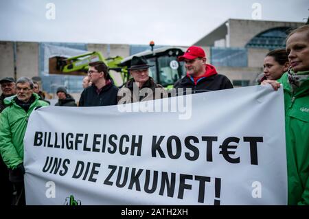 Berlin, Deutschland. Februar 2020. Aktivisten der "Arbeitsgemeinschaft bäuerliche Landwirtschaft" und der Umweltschutzorganisation Greenpeace stehen vor dem Bundeskanzleramt mit einem Banner "Billiges Fleisch kostet uns die Zukunft". Im Streit um die Lebensmittelpreise in Supermärkten diskutieren Vertreter des Einzelhandels und der Lebensmittelindustrie bei einem Spitzentreffen mit Kanzlerin Merkel, Landwirtschaftsminister Klöckner und Wirtschaftsminister Altmaier über Lösungen. Credit: Michael Kappeler / dpa / Alamy Live News Stockfoto