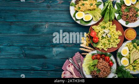 Eine Reihe von Lebensmitteln aus Buchweizen, Bulgur und Pasta. Auf Holzgrund. Draufsicht. Kopierbereich. Stockfoto