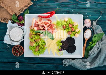 Kalte Snacks. Speck, Käse, Leberpastete. Draufsicht. Auf Holzgrund. Kopierbereich. Stockfoto