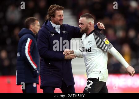 Wayne Rooney von Derby County schüttelt mit Manager Phillip Cocu (links) die Hände, da er während des Sky Bet Championship Matches im Pride Park, Derby, ersetzt wird. Stockfoto