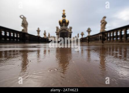 Dresden, Deutschland. Februar 2020. Das Kronentor im Dresdner Zwinger spiegelt sich in einer Pfütze wider, während es regnet. Kredit: Robert Michael / dpa-Zentralbild / dpa / Alamy Live News Stockfoto