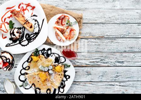 Desserts: Pfannkuchen, Eis, Süßigkeiten. Draufsicht. Freier Speicherplatz für Ihren Text. Rustikaler Stil. Stockfoto