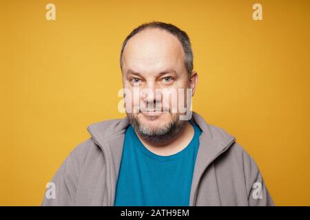 Lässiger, vom selbstbewussten reifen Mann vor gelbem Hintergrund mit Kopierbereich Stockfoto