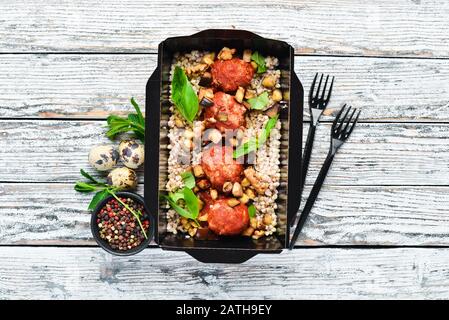 Fleischbällchen in Tomatensauce mit Buchweizen gebacken. Gewichtsverlust Ernährung in Kisten. Draufsicht. Freier Speicherplatz für Ihren Text. Stockfoto