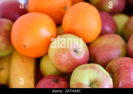 Stillleben mit einem Haufen frischer und köstlicher Äpfel und Orangen, die in einem Metallbogen liegen Stockfoto