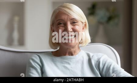 Kopfbildfoto der fröhlichen reifen Frau, die sich positiv fühlt Stockfoto