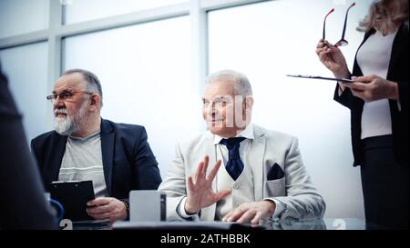 Nahaufnahme: Geschäftspartner sitzen am Verhandlungstisch. Stockfoto