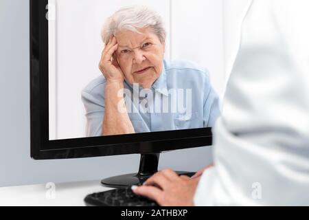 Telemedizin und E-Health mit einem Arzt und einer älteren Frau mit Bedrängnis, Patient auf dem Desktop Stockfoto