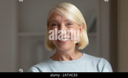 Porträt einer lächelnden Frau mittleren Alters, die zu Hause posiert Stockfoto