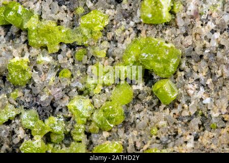 Nahaufnahme eines peridot- oder olivin-mineralischen Steinmusters Hintergrund, Details und Makro der Mineralogie Stockfoto