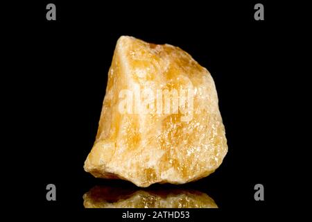 Roher oranger Kalzit mineralischer Stein vor schwarzem Hintergrund, Mineralogie und Esoterik Stockfoto