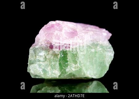 Roher grüner und rosafarbener tourmaliner Mineralstein vor schwarzem Hintergrund, Mineralogie und Esoterik Stockfoto