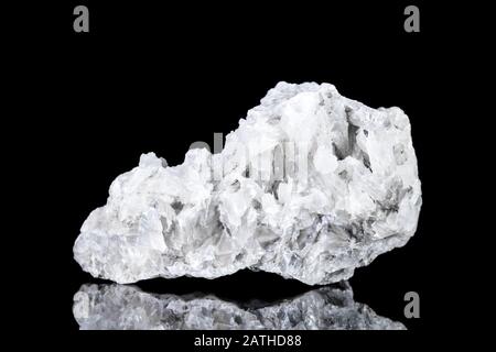 Roher weißer Kalzit mineralischer Stein vor schwarzem Hintergrund, Mineralogie und Esoterik Stockfoto
