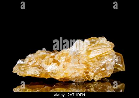 Rohhonig kalzitieren Mineralstein vor schwarzem Hintergrund, Mineralogie und Esoterik Stockfoto