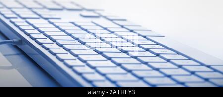 Nahansicht der Computertastatur in blauer Farbe. Weicher Fokus in der Bildmitte. Nützliches horizontales Banner. Stockfoto