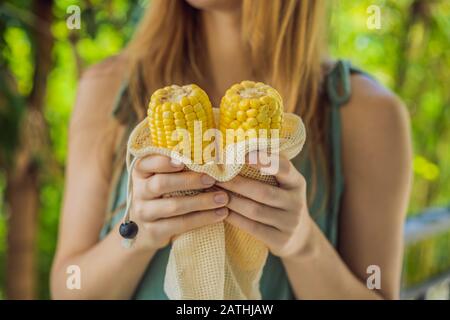 Mais in einer wiederverwendbaren Tasche in den Händen einer jungen Frau. Null-Abfall-Konzept Stockfoto