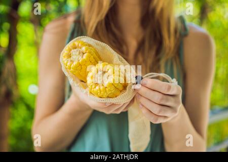 Mais in einer wiederverwendbaren Tasche in den Händen einer jungen Frau. Null-Abfall-Konzept Stockfoto