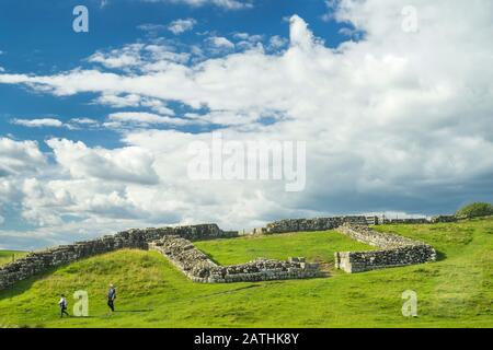 Menschen, die vor Milecastle 42, Hadrians Wall Country, Northumberland, England spazieren gehen Stockfoto