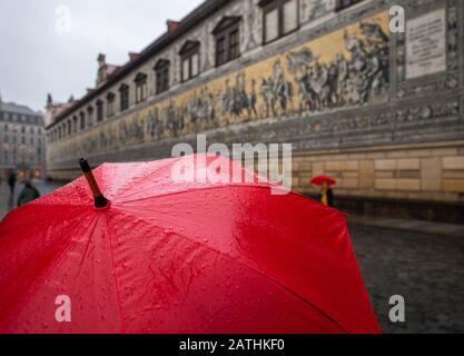 Dresden, Deutschland. Februar 2020. Touristen wandern im Regen unter Sonnenschirmen am Fürstenzug entlang. Credit: Dpa Picture Alliance / Alamy Live News Stockfoto