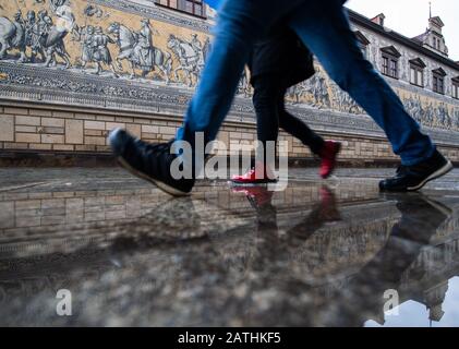 Dresden, Deutschland. Februar 2020. Touristen gehen durch eine Pfütze auf dem Fürstenzug im Regen. Credit: Dpa Picture Alliance / Alamy Live News Stockfoto