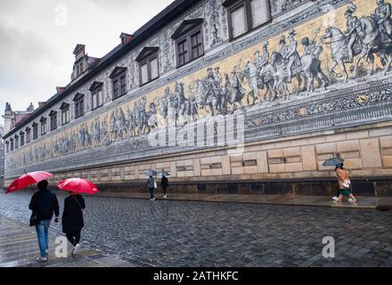 Dresden, Deutschland. Februar 2020. Touristen wandern im Regen unter Sonnenschirmen am Fürstenzug entlang. Credit: Dpa Picture Alliance / Alamy Live News Stockfoto