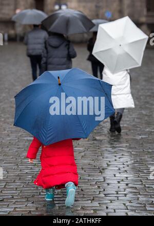 Dresden, Deutschland. Februar 2020. Touristen laufen unter Regenschirmen über den Neumarkt, wenn es regnet. Credit: Dpa Picture Alliance / Alamy Live News Stockfoto