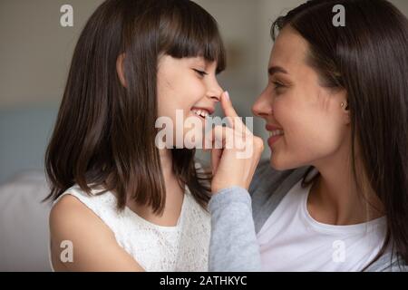 Liebende Mutter und kleine Tochter spielen zu Hause Stockfoto