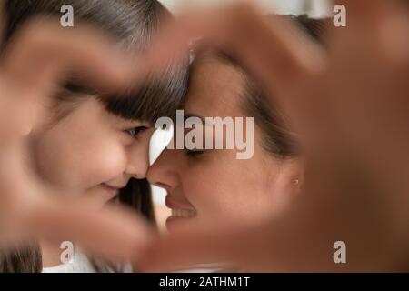 Liebevolle junge Mutter und kleine Tochter teilen einen Moment Stockfoto