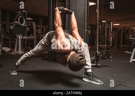 Ein bärtiger sportlicher Mann im Fitnessstudio macht Yoga- und Kampfkunstübungen. Stockfoto
