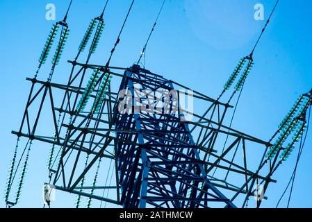 Zu den Telekommunikationstürmen gehören eine Funk-Mikrowelle und ein Fernsehantennensystem mit wolkenblauem Himmel und Sonnenstrahlen. Antennensturm, niedrige Winkelansicht. Stockfoto