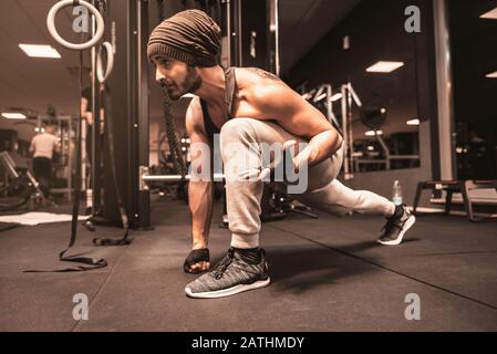 Ein bärtiger sportlicher Mann im Fitnessstudio macht Yoga- und Kampfkunstübungen. Stockfoto