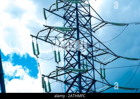 Zu den Telekommunikationstürmen gehören eine Funk-Mikrowelle und ein Fernsehantennensystem mit wolkenblauem Himmel und Sonnenstrahlen. Antennensturm, niedrige Winkelansicht. Stockfoto