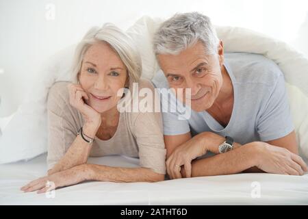 Portrait von Happy attraktive senior Paar im Bett Stockfoto