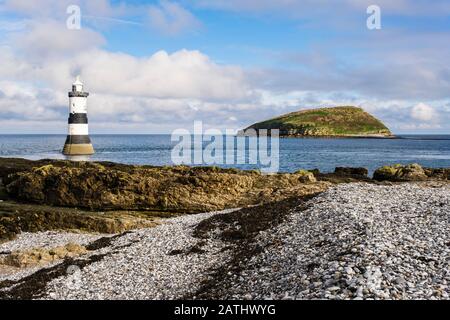 Leuchtturm Penmon und Insel Puffin (Ynys Seiriol) vom Kieselstrand am Penmon Point (Trwyn Du), Insel Anglesey, Wales, Großbritannien Stockfoto