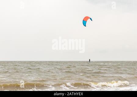 Ein Kitesurfer springt an der Nordsee nahe der Küste der Niederlande aus dem Wasser. Stockfoto