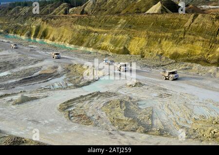 Große gelbe Bergbau-Lastwagen, die im Kalk-Tagebau arbeiten. Beladung und Transport von Mineralien im Kreide-Tagebau. Weißrussland, Krasnoselsk, im Stockfoto