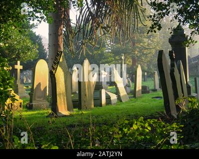 Alte Grabsteine in den Flaybrick Memorial Gardens/Friedhof in Birkenhead, Großbritannien. GROSSBRITANNIEN. Am späten Nachmittag wird die Wintersonne eingenommen. Stockfoto