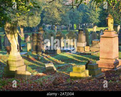 Alte Grabsteine in den Flaybrick Memorial Gardens/Friedhof in Birkenhead, Großbritannien. GROSSBRITANNIEN. Am späten Nachmittag wird die Wintersonne eingenommen. Stockfoto