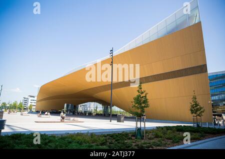 Neue Zentralbibliothek Helsinki Oodi Exterieur. Moderne nördliche Architektur. Eingang des Gebäudes auf dem Stadtplatz, sonniger Sommertag. Stockfoto