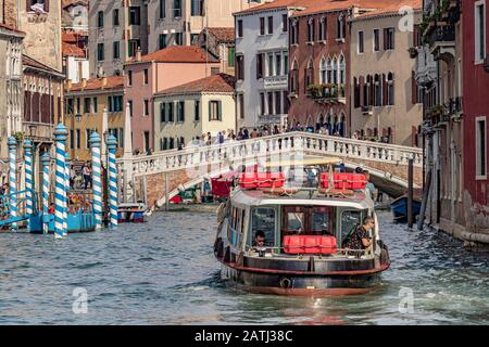 Ein Mann bewundert den Blick von der Rückseite eines Vaporetto- oder Wasserbusses, da er auf dem Weg zur Ponte delle Guglie ist, einer Kanalbrücke in Venedig, Italien Stockfoto