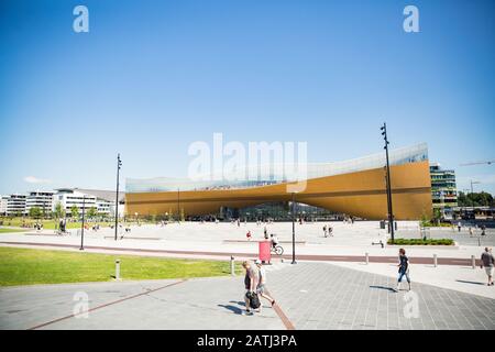 Neue Zentralbibliothek Helsinki Oodi Exterieur. Moderne nördliche Architektur. Eingang des Gebäudes auf dem Stadtplatz, sonniger Sommertag. Stockfoto