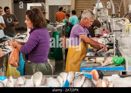 Fischer wäscht Fisch auf einem Fischmarkt Stockfoto