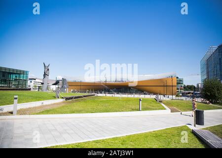 Neue Zentralbibliothek Helsinki Oodi Exterieur. Moderne nördliche Architektur. Eingang des Gebäudes auf dem Stadtplatz, sonniger Sommertag. Stockfoto