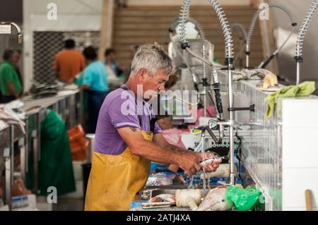 Fischer wäscht Fisch auf dem Markt Stockfoto