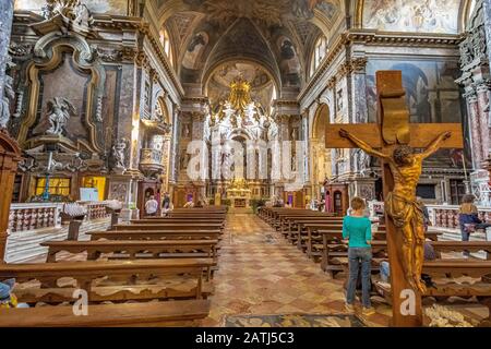 Eine Frau steht in der Nähe eines Kruzifixes im Inneren der Kirche Santa Maria di Nazareth, Venedig, Italien Stockfoto