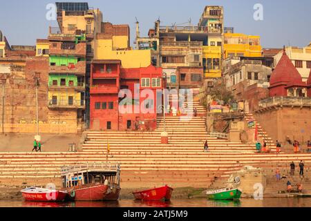 Varanasi, INDIEN, 18. JANUAR 2019: Warme Sonnenaufgangsfarben über Varanasi Ghats und Kolofrol-Gebäude. Stockfoto